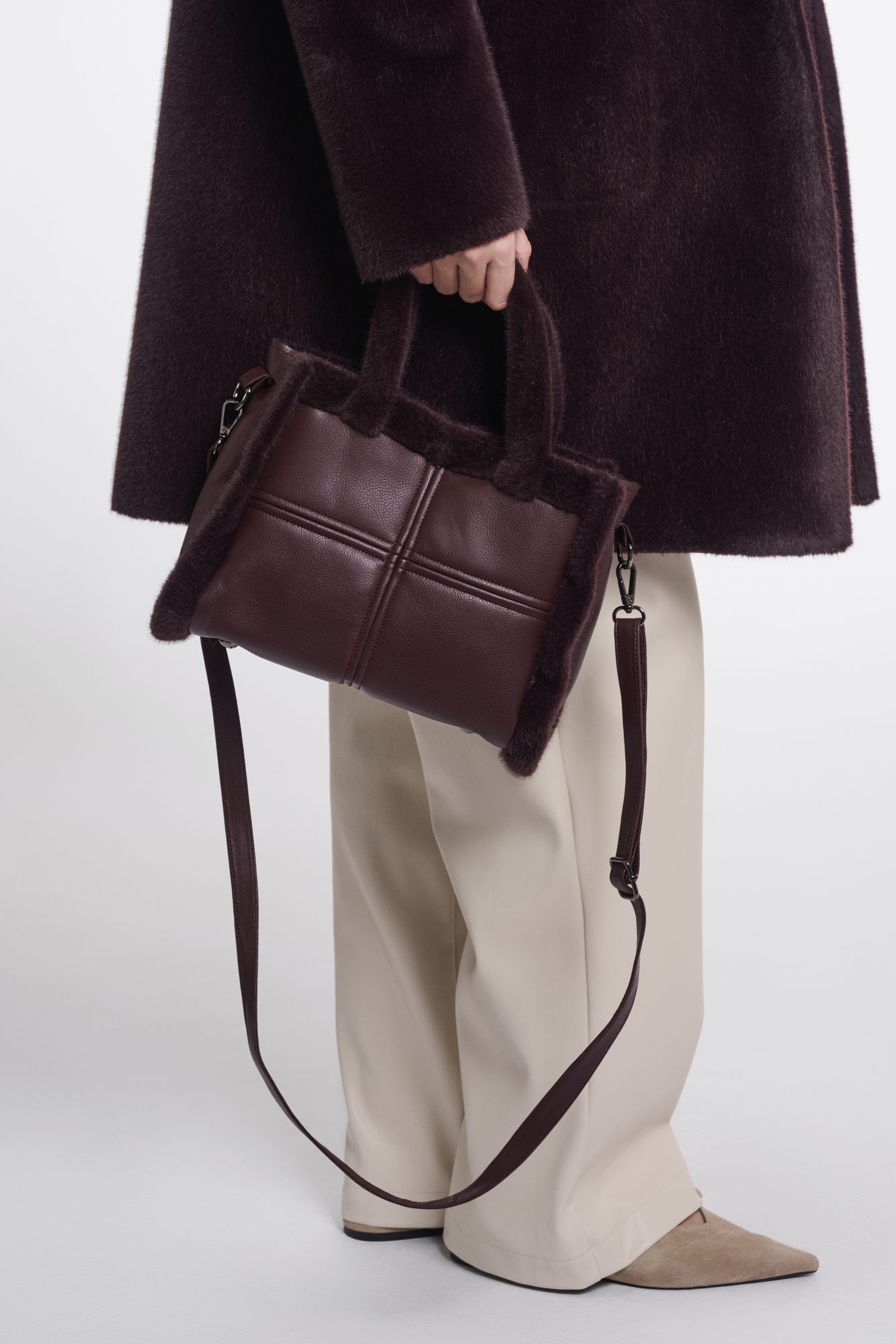 Handtas in de kleur fudge bij een crème broek